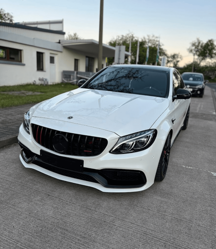 Weißer Mercedes nach gründlicher Autopflege mit poliertem Lack und glänzender Frontpartie